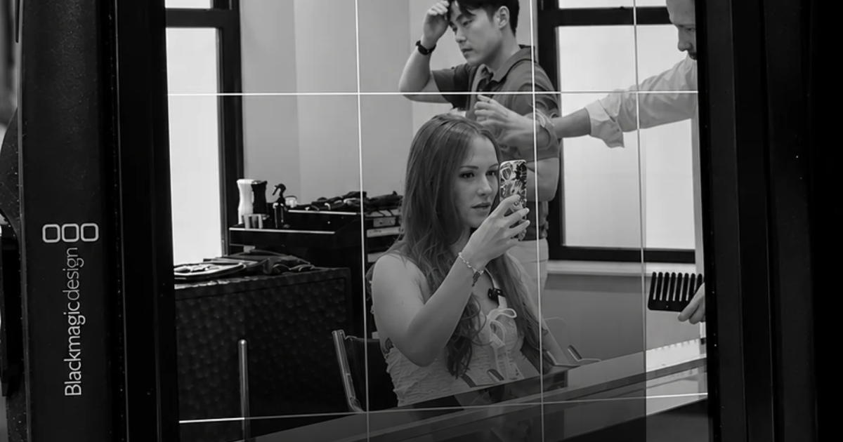Woman filming a selfie video in a salon chair, seen through a cinema camera monitor during a Link Creative content shoot